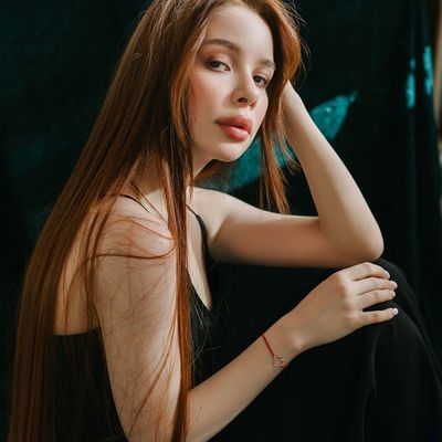 Person sitting peacefully with eyes closed in a calm setting.